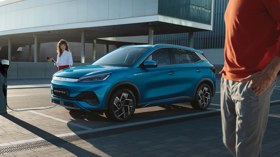 Image of a light metallic blue BYD Seal U DM-i charging outside a modern house
